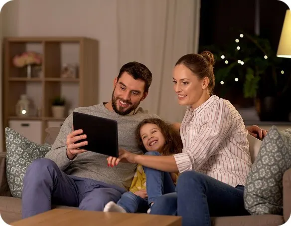 A family on the sofa looking at a tablet together