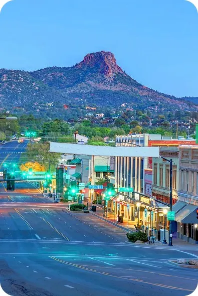 Downtown Prescott at dusk with Thumb Butte behind it