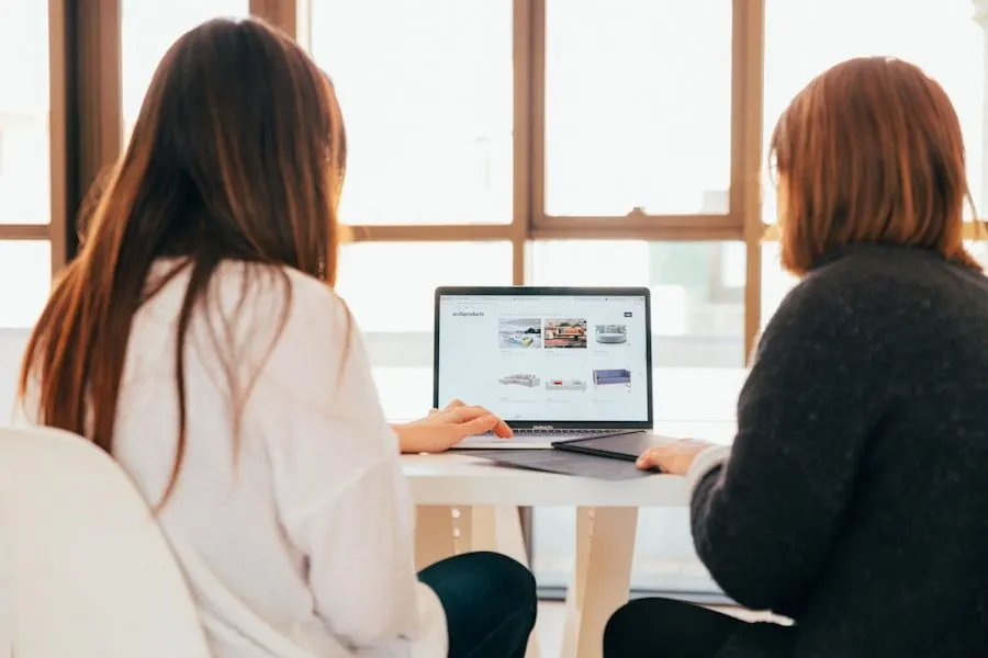 Two people looking at a laptop together at a table